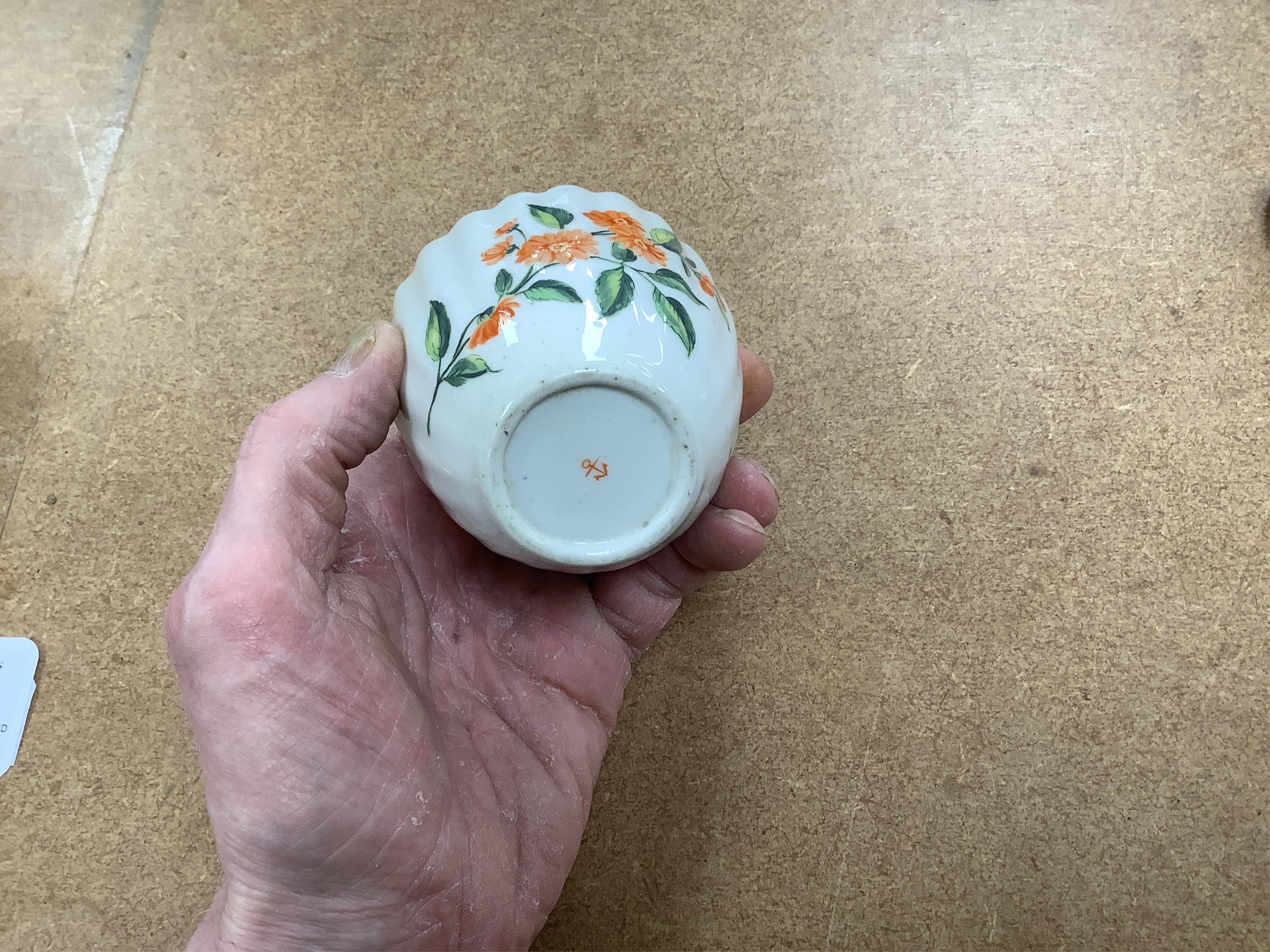 Worcester polychrome tea and coffee wares, c.1760-1780, comprising a tea caddy, a cream jug, five coffee cups and a fluted bowl, the latter with red anchor mark (8), largest tea caddy 14cm high.
